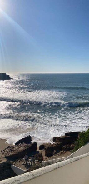 Beautiful seaside landscape with waves crashing on the shore under clear blue sky.